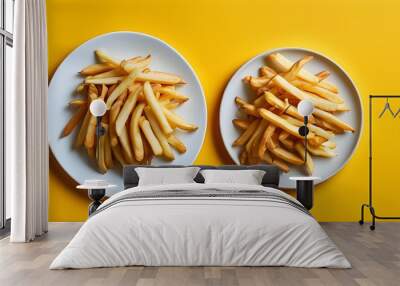 Crispy French fries arranged on a white plate against a vibrant yellow background Wall mural