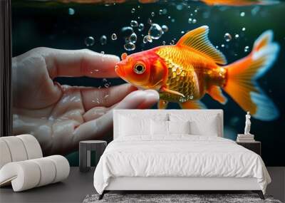 Delicate touch of a hand cradling a goldfish in shimmering water Wall mural