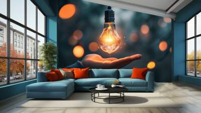 Embracing Innovation: A Person Holds a Glowing Light Bulb in a Serene Environment Wall mural