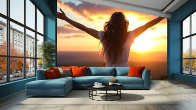 Joyful woman embracing the sunset in nature with open arms Wall mural