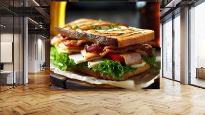 Savory sandwich topped with meat, cheese, bacon, lettuce, and tomato, paired with refreshing beer, ideal for a satisfying lunch or dinner. Wall mural