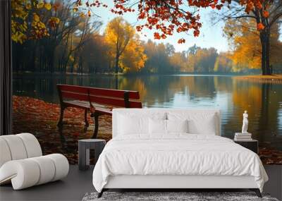 Serene autumn landscape featuring a red bench by a lake reflecting vibrant fall foliage in a sunny park Wall mural