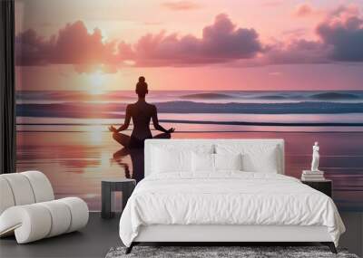 Serene sunset meditation on the beach with a silhouetted figure and tranquil ocean backdrop Wall mural