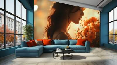 Silhouette of a woman admiring a bouquet against a warm, orange-toned blurred background Wall mural