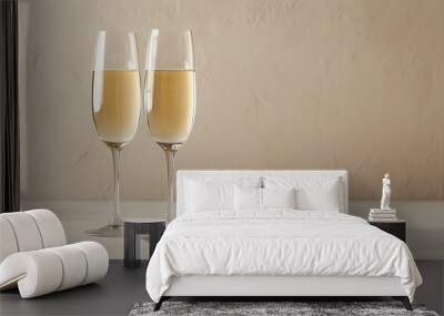 Stylish glass champagne glasses on a soft beige backdrop with ample empty copy space for text or design elements Wall mural