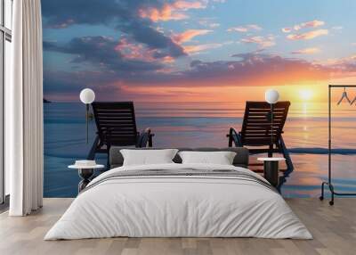 Tranquil beach setting with two chairs overlooking a stunning sunset over peaceful waters Wall mural