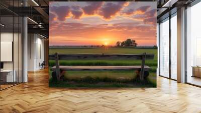 Tranquil sunset view from a rustic wooden bench overlooking a serene countryside field Wall mural