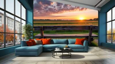 Tranquil sunset view from a rustic wooden bench overlooking a serene countryside field Wall mural