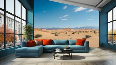 Vast desert scene featuring rolling sand dunes, minimal vegetation, and a clear blue sky framed by distant mountain silhouettes Wall mural