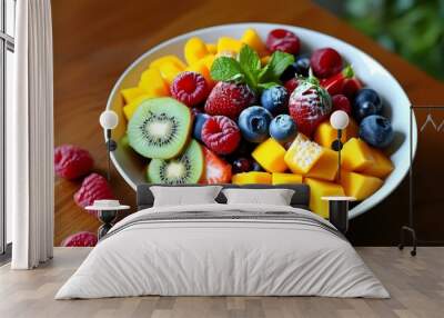 Vibrant bowl of fresh fruit salad featuring mango, kiwi, strawberries, raspberries, and blueberries for a healthy and delicious treat Wall mural