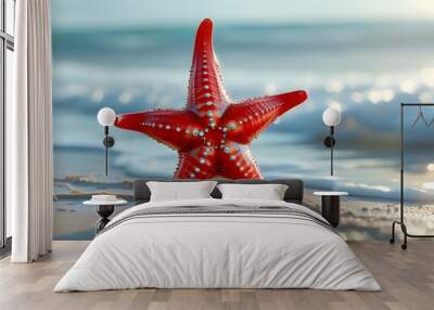 Vibrant red starfish resting on golden beach sand under bright sunlight Wall mural