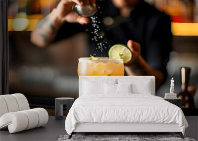 Craftsmanship in Action: Bartender Preparing Fresh Margarita with Salted Rim Under Ambient Bar Lighting Wall mural