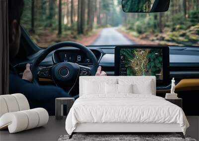 A person is driving a car, holding the steering wheel and looking at an open tablet displaying a map that shows their location Wall mural