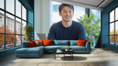 An Asian business man is sitting at a table, smiling and staring ahead, having a business chat with two people across from him Wall mural