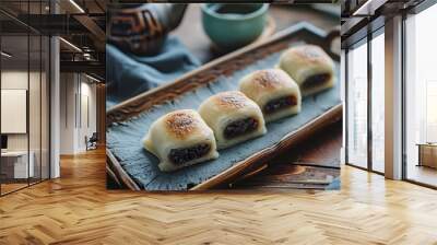 Product photography, Chinese food, Three steamed buns filled with black rice and red dates inside the square shaped brown sugar cake on a rectangular grey plate placed on a wooden tray with a blue clo Wall mural