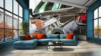 Close-up of a car salesman writing on a clipboard at a modern dealership Wall mural