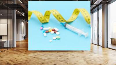 Diet pills, syringes, rulers and other weight-loss materials placed on the table Wall mural