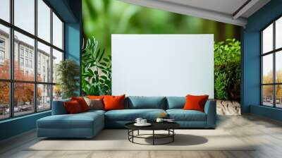 A white blank paper is placed next to the green plants with a natural wooden floor in the background, giving a feeling of tranquility and nature. Wall mural