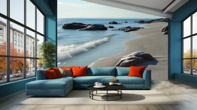 The fine sand and rocks on the coastline are tranquil under soft light, and the sparkling sea in the distance contrasts sharply with the tranquil sandy beach. Wall mural