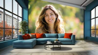 A beautiful woman in her late thirties smiling and standing outside, wearing comfortable with light colors Wall mural