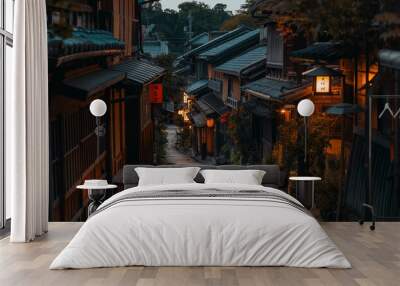 Photograph of a view down the hillside street in Kyoto, Japan, showing wooden buildings and bamboo walls with some autumn foliage on both sides of the narrow cobblestone streets at sunrise Wall mural