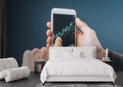 Finger pointing to smartphone for stock trading Wall mural