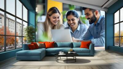 Successful diverse business team reviewing legal and financial documents, discussing an agreement at the laptop, smiling and laughing while doing paperwork together in a collaborative environment Wall mural