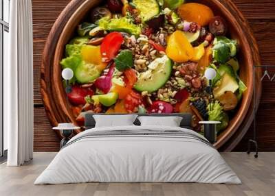 A beautifully arranged fresh salad with vibrant vegetables, sprinkled with nuts and seeds, served in a rustic bowl on a wooden table Wall mural