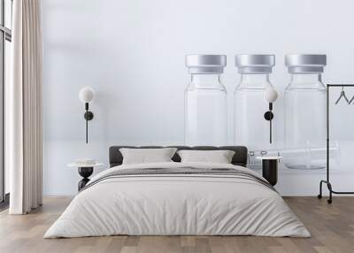 small glass vials with clear liquid and a syringe on a white background, close-up. Wall mural